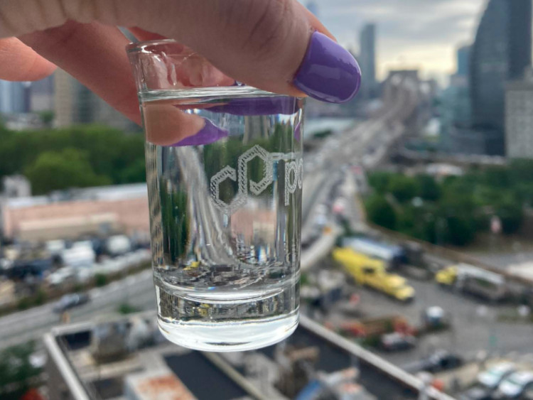 A picture of a polygon customized shotglass with NYC behind it